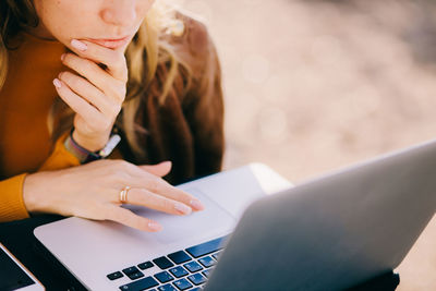 Midsection of woman using laptop