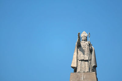 Low angle view of statue against blue sky