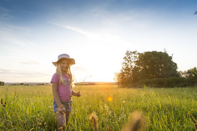 Woman standing on grassy field against sky