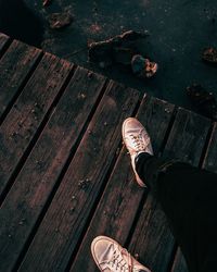 Low section of man standing on wooden floor