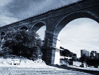 Low angle view of bridge against cloudy sky