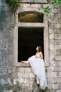 Woman standing against white wall