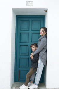 Portrait of siblings standing by door