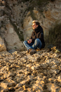 Young woman sitting on rock