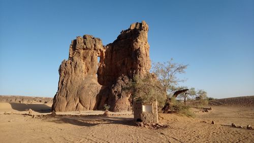 Rock formation on land against clear blue sky