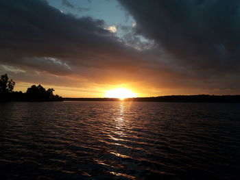 Scenic view of sea against dramatic sky during sunset