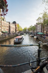 Canal amidst buildings in city against sky