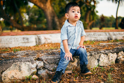 Full length of a boy sitting outdoors