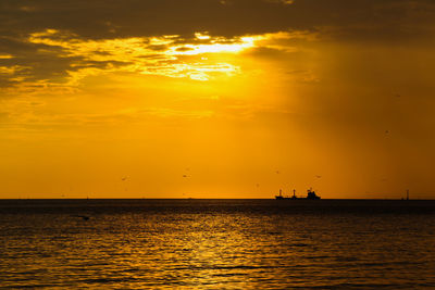 Scenic view of sea against orange sky