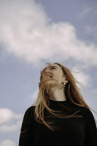 Portrait of a beautiful young woman against sky