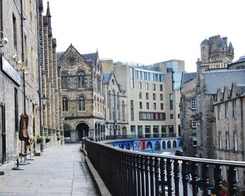 Street amidst buildings in city against clear sky