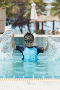 Boy happy swimming in a pool. children swimming and playing in water.