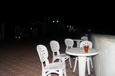 Chairs and tables at illuminated restaurant