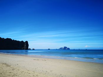 Scenic view of beach against blue sky