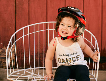 Portrait of a young girl toddler in the backyard wearing a biking helmet