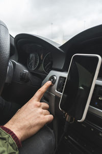 Man pushing start button in car