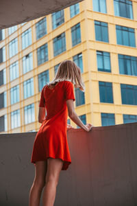 Rear view of woman standing against building