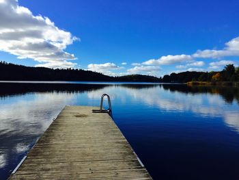 Pier over lake against blue sky