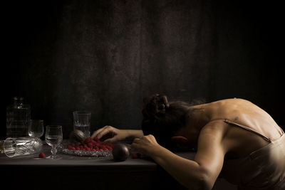 Woman offering a passion fruit between crystal crockery v