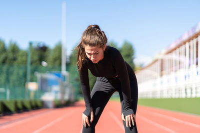 Tired woman resting on track