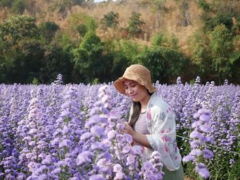 Full length of woman with pink flowers on field