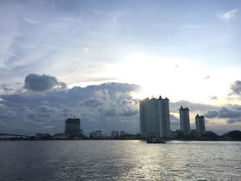 Sea by buildings against sky in city