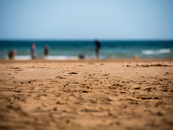 Surface level of beach against clear sky