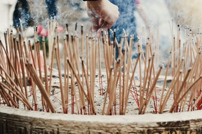 Cropped hand holding burning incense