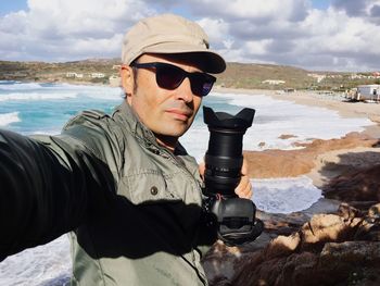 Man holding camera at beach