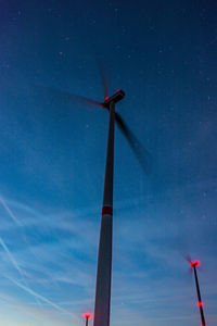 Low angle view of wind turbine against blue sky