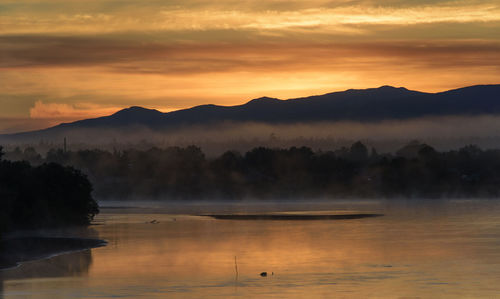 Scenic view of lake against sky at sunset