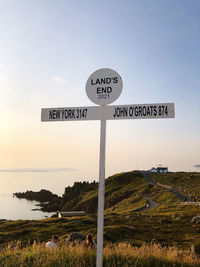 Information sign on land against sky