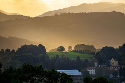 High angle view of trees and buildings against sky during sunset