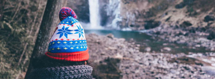 Close-up of person wearing knit hat at forest