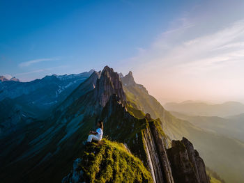 Panoramic view of people standing on mountain against sky