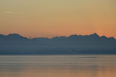 Scenic view of dramatic sky over mountains during sunset