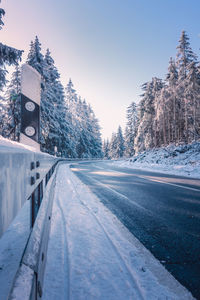 Road amidst trees against clear sky