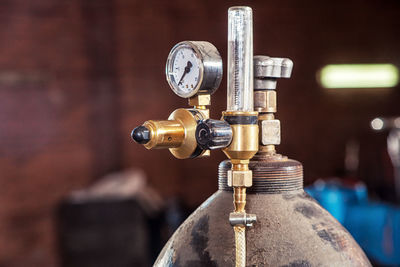 Close-up of a metal gas cylinder with a reducer and a pressure 