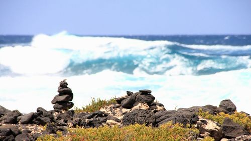 Scenic view of sea by rock formation against sky