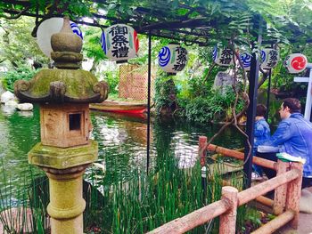 Men by tree against water