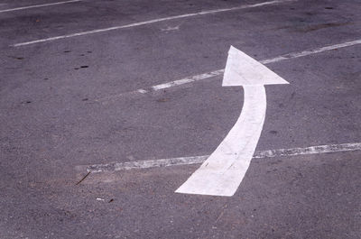 Close-up of arrow sign on road