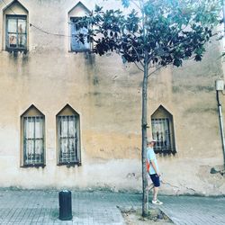 Full length of woman walking by building