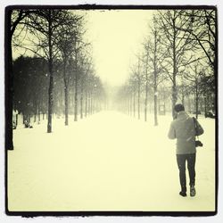 Rear view of people walking on snow covered landscape