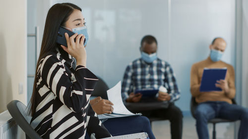 Woman talking on mobile phone wearing protective face mask