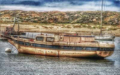 Boats in river against sky