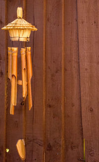 Close-up of wind chime hanging against wooden wall