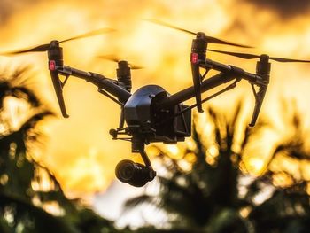 Low angle view of silhouette camera against sky during sunset