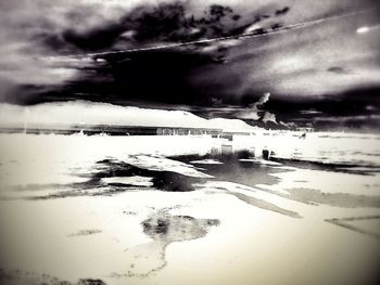 Scenic view of beach against cloudy sky