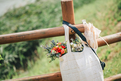 Close-up of flowers in bag hanging on railing