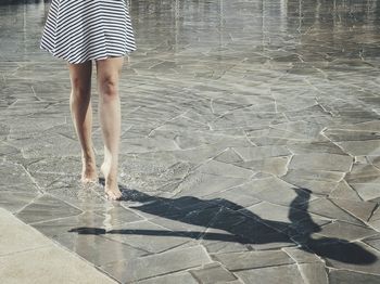 Low section of woman standing on tiled floor